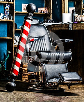 Closeup armchair. Barber shop pole. Logo of the barbershop, symbol. Stylish vintage barber chair. Barbershop armchair