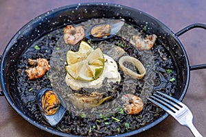 Closeup of Arros negre served on a pan in a restaurant photo