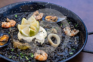 Closeup of Arros negre served on a pan in a restaurant