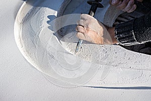 Closeup of an artist carving curves into a white stone