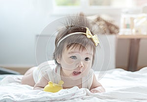 Closeup asian baby girl lie on carpet  in cute motion