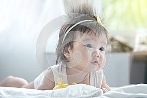 Closeup asian baby girl lie on carpet  in cute motion