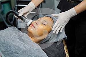 Closeup Asian beauty woman having therapy to stimulate facial skin and facial ultrasonic skincare treatment