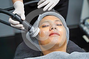 Closeup Asian beauty woman having therapy to stimulate facial skin and facial ultrasonic skincare treatment by professional