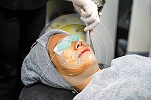 Closeup Asian beauty woman ware eyepatch and receiving skin gel to prepare the color light therapy to stimulate facial health