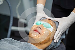 Closeup Asian beauty woman ware eyepatch and receiving skin gel to prepare the color light therapy to stimulate facial health