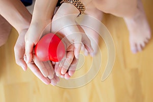 Closeup asian couple holding a red heart shape on hands, hands of man and woman feeling happiness and romantic