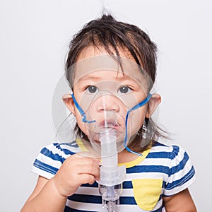 Closeup Asian face, Little baby girl sick her using steam inhaler nebulizer mask inhalation oneself