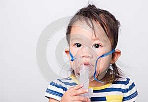 Closeup Asian face, Little baby girl sick her using steam inhaler nebulizer mask inhalation oneself