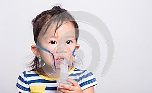 Closeup Asian face, Little baby girl sick her using steam inhaler nebulizer mask inhalation oneself