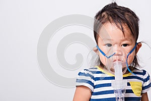 Closeup Asian face, Little baby girl sick her using steam inhaler nebulizer mask inhalation oneself