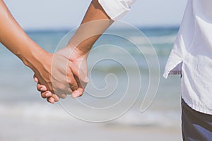 Closeup asian gay couple holding hands together on the beach with relax and leisure in summer