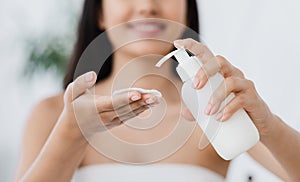 Closeup of asian girl applying cleansing lotion on cotton pad