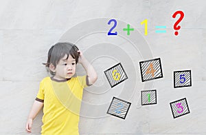 Closeup asian kid with confuse face by mathematic question on marble stone wall textured background