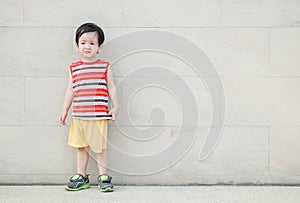 Closeup asian kid do not look satisfied with something on marble stone wall textured background with copy space