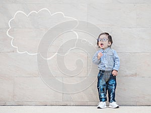 Closeup asian kid say something action with text box on marble stone wall textured background with copy space