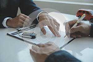 Closeup asian male people car salesman or sales manager offers to sell a car and explains and reads the terms of signing a car