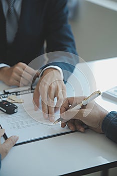 Closeup asian male people car salesman or sales manager offers to sell a car and explains and reads the terms of signing a car