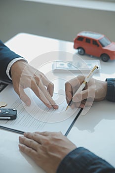 Closeup asian male people car salesman or sales manager offers to sell a car and explains and reads the terms of signing a car