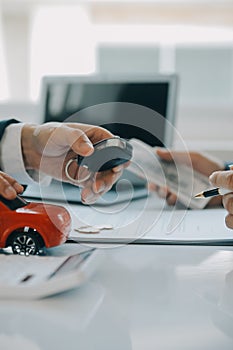 Closeup asian male people car salesman or sales manager offers to sell a car and explains and reads the terms of signing a car