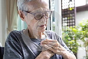 Closeup,Asian senior woman sit in wheelchair suffering chest pain,suffocation and chest tightness or panic disease,old elderly photo