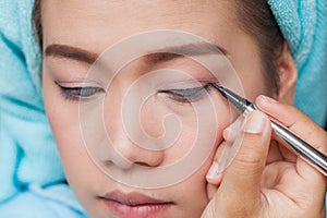 Closeup asian woman applying eyeliner on eye
