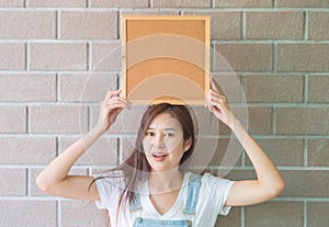 Closeup asian woman with cork board in hand with excited face