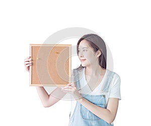Closeup asian woman with cork board in hand and look at the space in cork board isolated on white background with clipping path