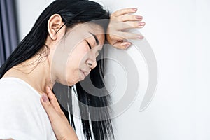 Asian woman fainting lean her head on the wall feeling dizzy photo