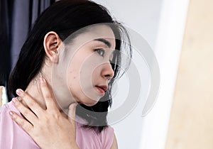 Ázijský žena mať akné pozdĺž kontrola jej v zrkadlo 