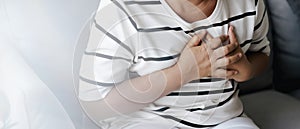 Closeup of asian woman having heart attack. Woman touching breast and having chest pain. Healthcare And Medical concept
