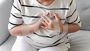 Closeup of Asian woman having heart attack. Woman touching breast and having chest pain. Healthcare And Medical concept