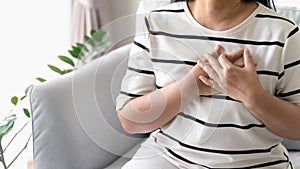 Closeup of Asian woman having heart attack. Woman touching breast and having chest pain. Healthcare And Medical concept