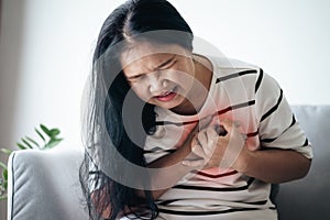 Closeup of Asian woman having heart attack. Woman touching breast and having chest pain. Healthcare And Medical concept