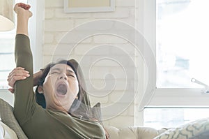 Closeup asian woman just wake up from a nap on sofa in living room textured background