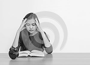 Closeup asian woman sitting for read a book with strain face emotion on wood table and white cement wall textured background in bl