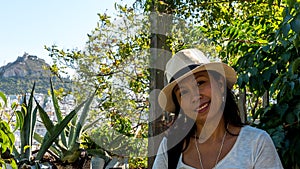 Closeup of Asian woman in white t-shirt and wearing hat in Athens with Lykavetos in the background photo