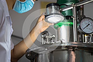 Closeup Asian worker working with ferment machine photo
