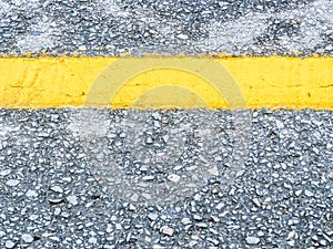 Closeup of asphalt street texture with yellow line