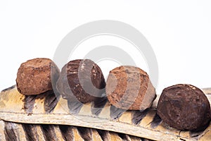 closeup of assortment of chocolate truffles on a wooden pod