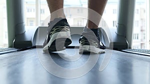 Closeup of athlete`s feet running on treadmill