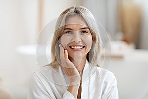 Closeup of attractive blonde woman touching her face