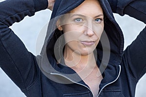 closeup of an attractive sexy young caucasian blonde girl wearing grey hoodie with an attitude isolated over white