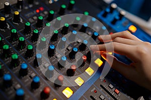 Closeup audio engineer hand on sound mixer control panel