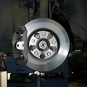 closeup of an automobile brake rotor disc with a hydraulic caliper