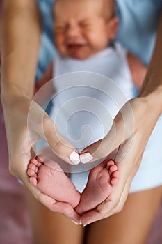 Closeup of baby feet and mother hands