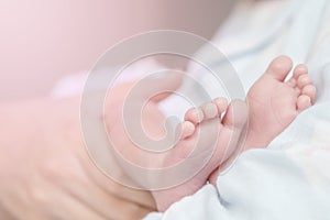 Closeup baby`s foot on mother`s arm