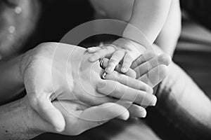 Closeup of baby's and parent's hands. black and white picture