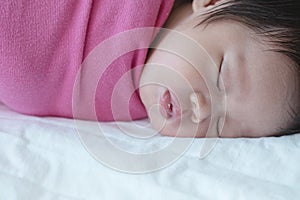 Closeup a baby sleeping comfortably on the bed