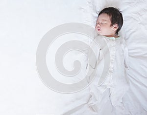 Closeup a baby sleeping comfortably on the bed with copy space